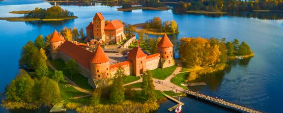 Auringon valossa kylpevä Trakain linna veden ympäröimänä Liettuassa