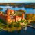 Auringon valossa kylpevä Trakain linna veden ympäröimänä Liettuassa